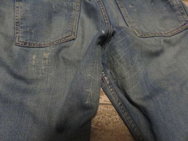 Butt of the jeans with a few mended areas visible