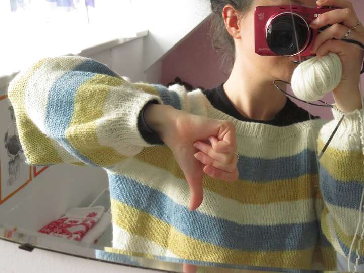 Same sweater, one arm shown, thumb down to show that the sleeve is a little short